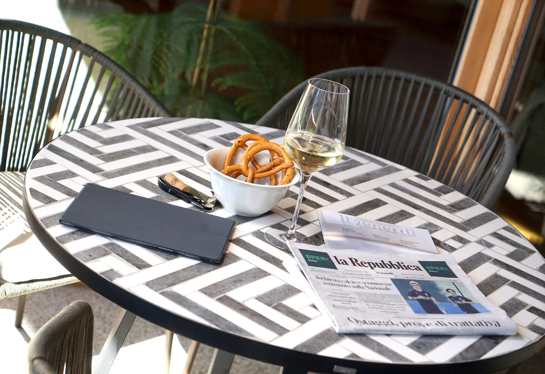 Der Tisch auf der Terrasse, Zeitung und Weißwein