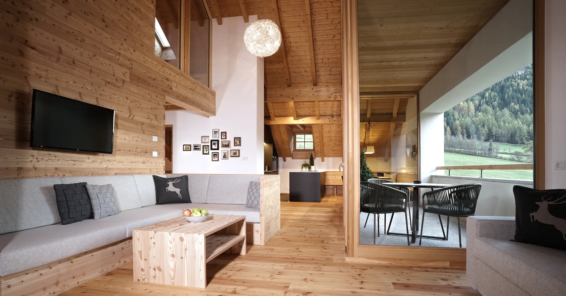 Der Wohnraum des Chalet Dolomites mit Galerie und Fensterfront nach Süden